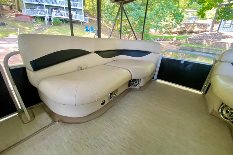 Slide: The Image of Interior of 2014 AquaPatio 220 WB pontoon boat with beige seating and scenic background. - 8