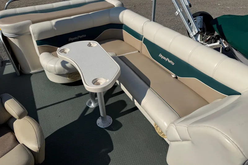 Slide: The Image of 2004 AquaPatio 240RE boat interior with beige seating and a central table. - 16