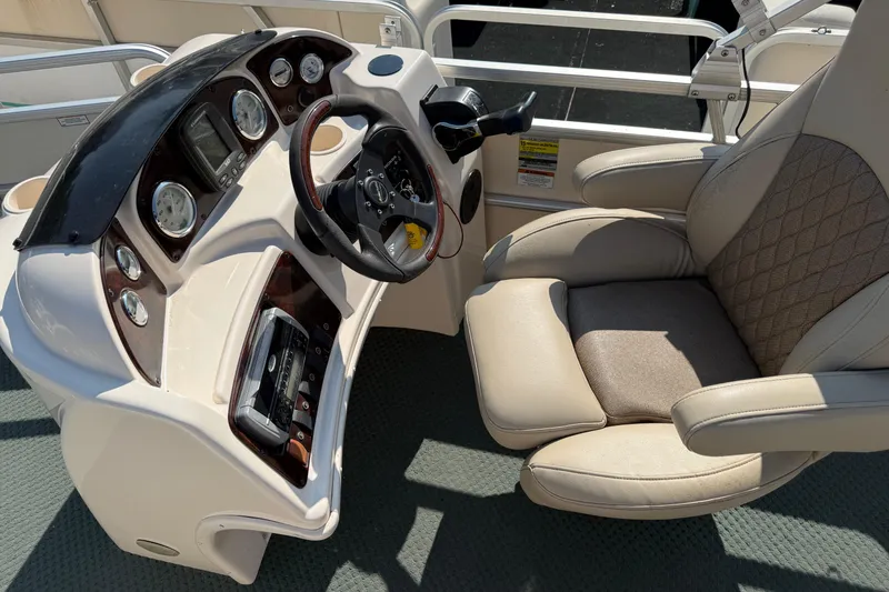 Slide: The Image of 2004 AquaPatio 240RE boat dashboard with steering wheel and comfortable captain's chair. - 17