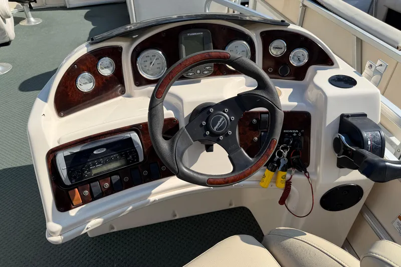 Slide: The Image of Control panel of a 2004 AquaPatio 240RE boat with steering wheel and gauges. - 18