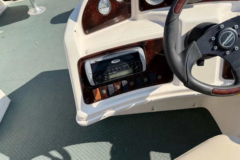 Slide: The Image of 2004 AquaPatio 240RE boat dashboard with steering wheel and control panel. - 19