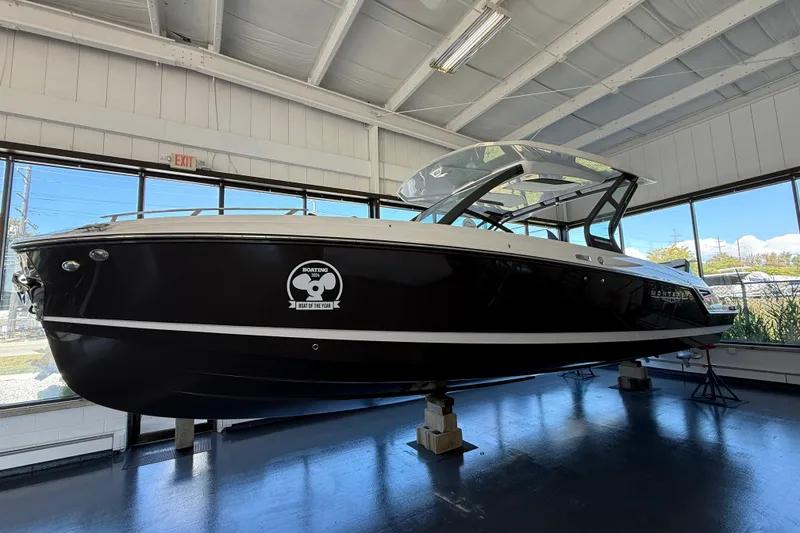 The Image of 2026 Monterey Elite 30 OB boat displayed indoors, showcasing sleek black design. - 0