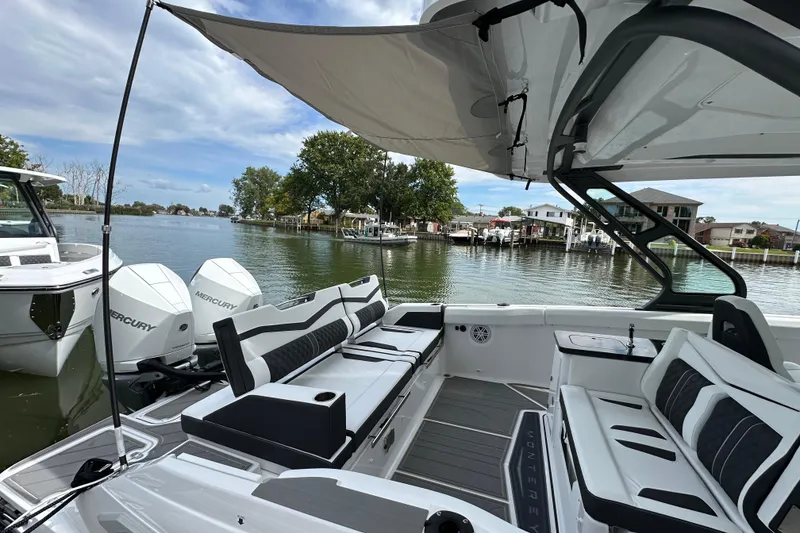 Slide: The Image of 2026 Monterey Elite 30 OB boat with luxurious seating and Mercury engines on a serene lake. - 15