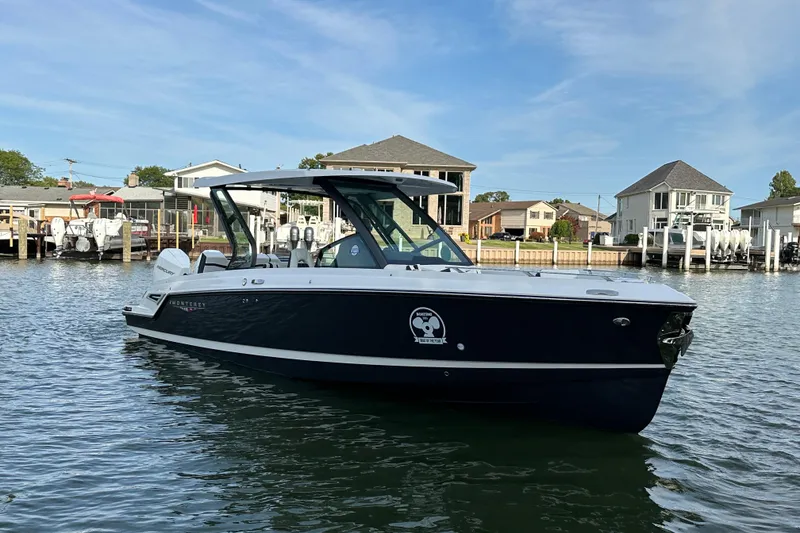 Slide: The Image of 2026 Monterey Elite 30 OB boat on calm water near residential docks. - 17