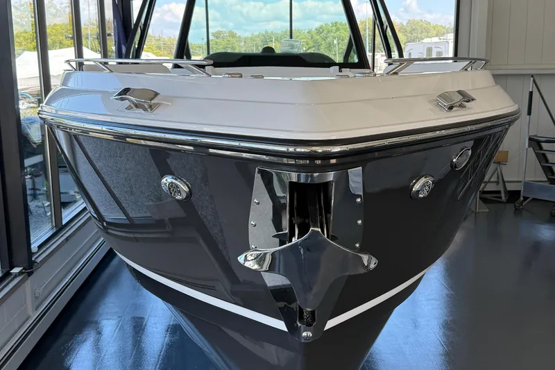 Slide: The Image of 2026 Monterey Elite 30 OB boat in showroom, sleek design with chrome accents. - 2