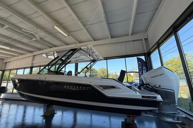 Slide: The Image of 2026 Monterey Elite 30 OB boat with Mercury engine in showroom. - 3