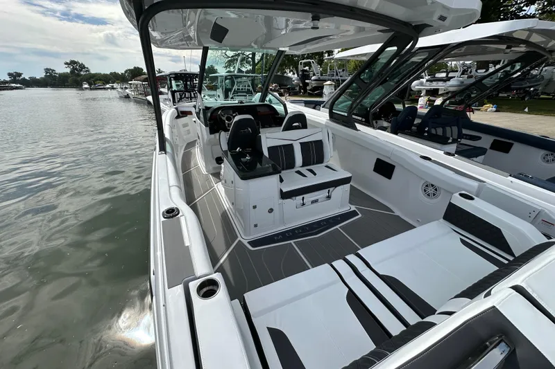 Slide: The Image of 2026 Monterey Elite 30 OB boat interior with sleek seating and modern design on a calm lake. - 6