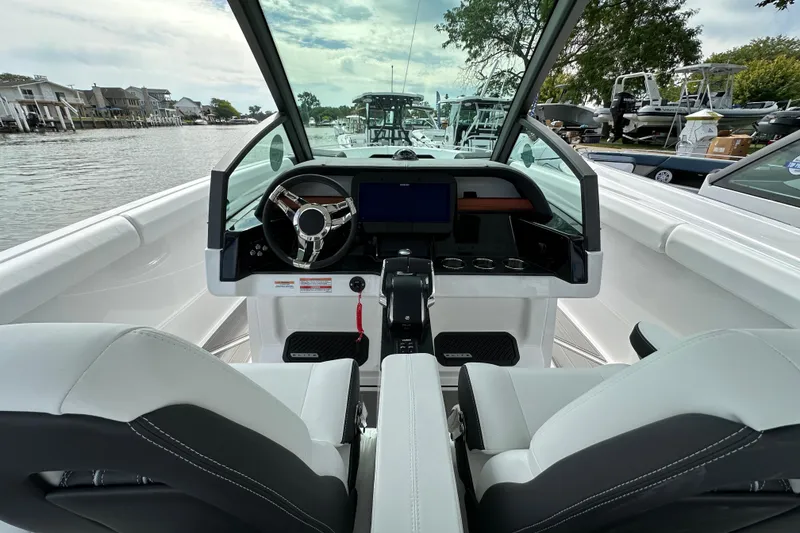 Slide: The Image of 2026 Monterey Elite 30 OB boat interior with modern dashboard and steering wheel, docked by the water. - 9