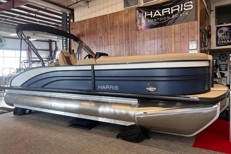 Slide: The Image of 2024 Harris Sunliner 230 pontoon boat displayed indoors, featuring sleek design and modern amenities. - 0