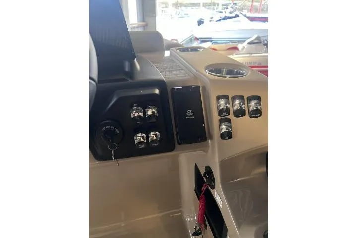 Slide: The Image of 2024 Harris Sunliner 230 boat dashboard with controls and cup holders. - 14