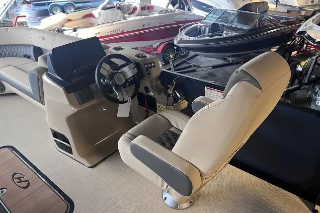 Slide: The Image of 2024 Harris Sunliner 230 boat interior with steering console and seating. - 15