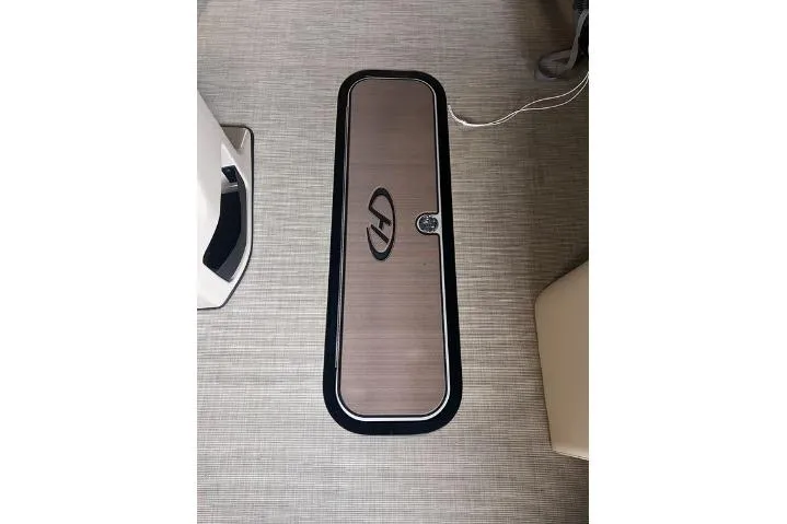 Slide: The Image of 2024 Harris Sunliner 230 boat floor hatch with sleek design and logo. - 16