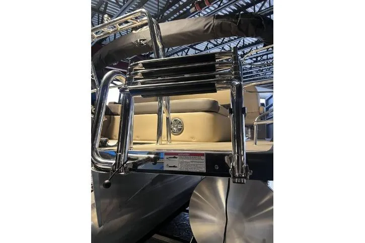 Slide: The Image of 2024 Harris Sunliner 230 boat ladder and seating detail in a showroom. - 25