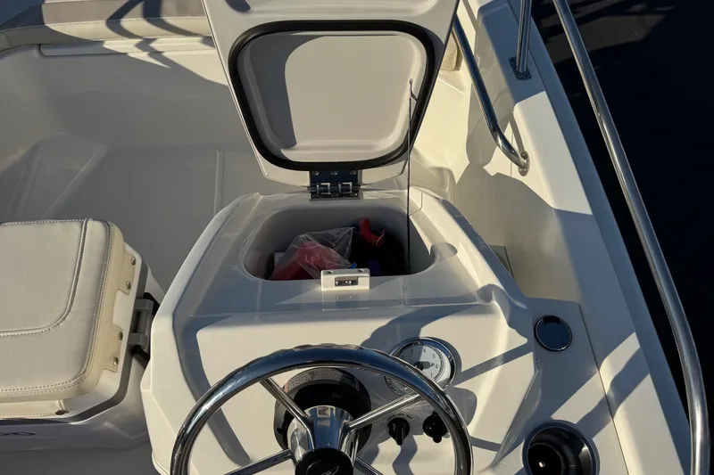 Slide: The Image of 2024 Boston Whaler 130 Super Sport boat console with open storage compartment. - 11