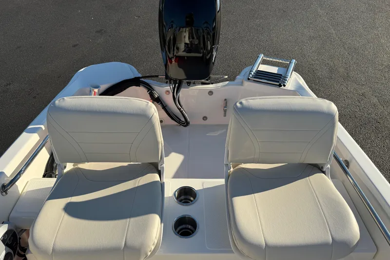 Slide: The Image of 2024 Boston Whaler 130 Super Sport boat interior with dual seats and motor. - 12