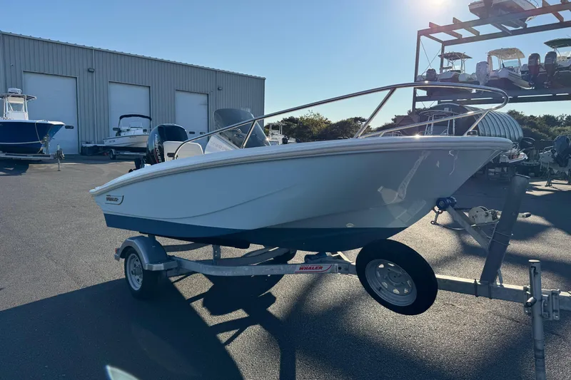 Slide: The Image of 2024 Boston Whaler 130 Super Sport boat on trailer in marina setting. - 3