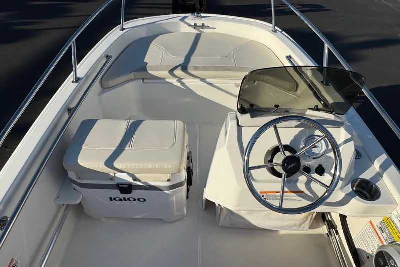 Slide: The Image of 2024 Boston Whaler 130 Super Sport boat interior with steering wheel and Igloo cooler. - 8