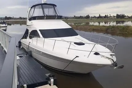 Slide: The Image of 2005 Sea Ray 420 Sedan Bridge yacht docked by a serene waterfront. - 0