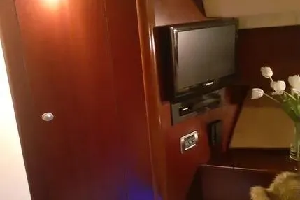 Slide: The Image of 2005 Sea Ray 420 Sedan Bridge interior with TV and elegant wood paneling. - 17