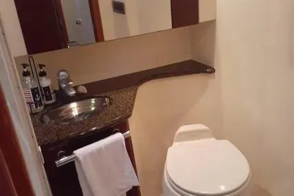 Slide: The Image of 2005 Sea Ray 420 Sedan Bridge bathroom with sink, toilet, and towel rack. - 19