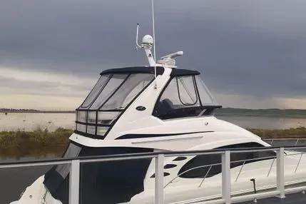 Slide: The Image of 2005 Sea Ray 420 Sedan Bridge yacht docked under cloudy skies. - 2
