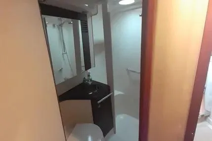 Slide: The Image of 2005 Sea Ray 420 Sedan Bridge bathroom interior with modern fixtures and mirror. - 20