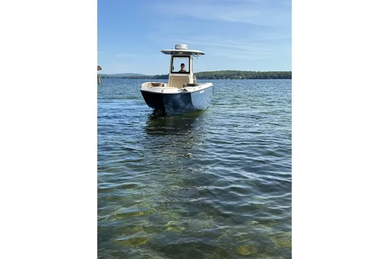Slide: The Image of 2023 Yamaha 252 FSH boat on clear lake water under blue sky. - 11