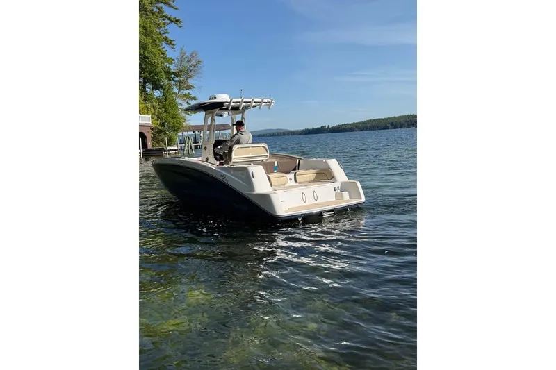 Slide: The Image of 2023 Yamaha 252 FSH boat on a serene lake with clear blue skies. - 13