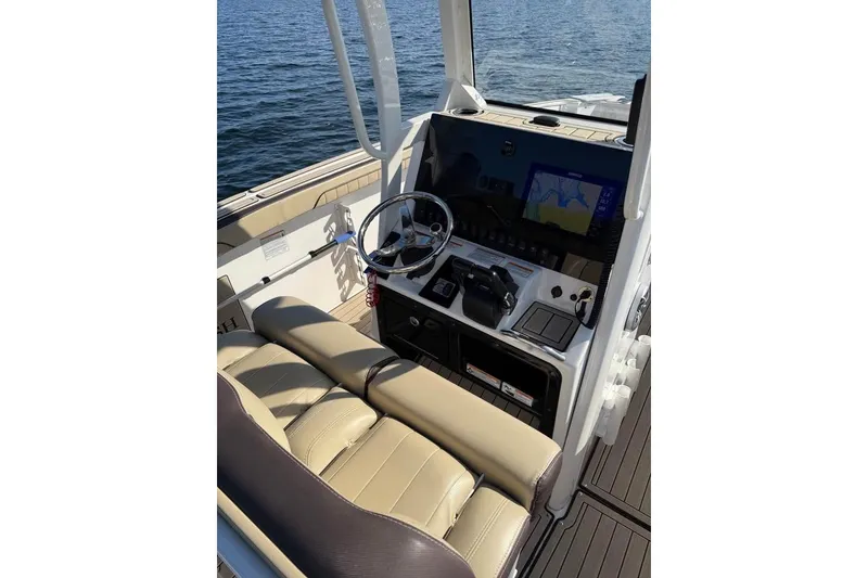 Slide: The Image of 2023 Yamaha 252 FSH boat cockpit with steering wheel and navigation display. - 14