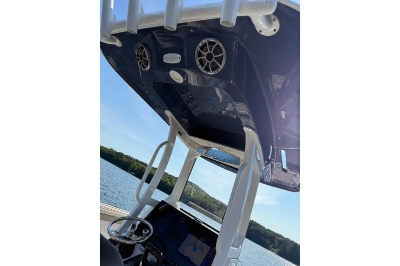 Slide: The Image of 2023 Yamaha 252 FSH boat console with speakers, steering wheel, and water view. - 2
