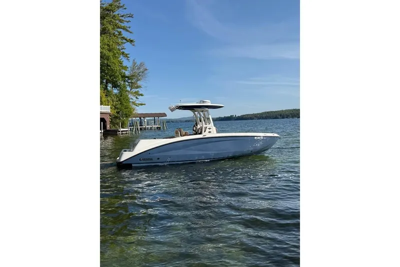 Slide: The Image of 2023 Yamaha 252 FSH boat on a serene lake with clear blue skies. - 3