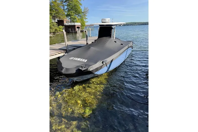 Slide: The Image of 2023 Yamaha 252 FSH boat covered and docked on a clear lake. - 5