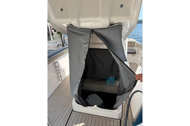 Slide: The Image of 2023 Yamaha 252 FSH boat interior with open storage compartment and gray cover. - 7
