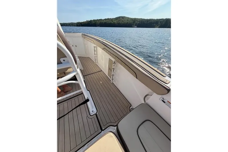 Slide: The Image of 2023 Yamaha 252 FSH boat interior with lake view, featuring sleek deck design. - 9