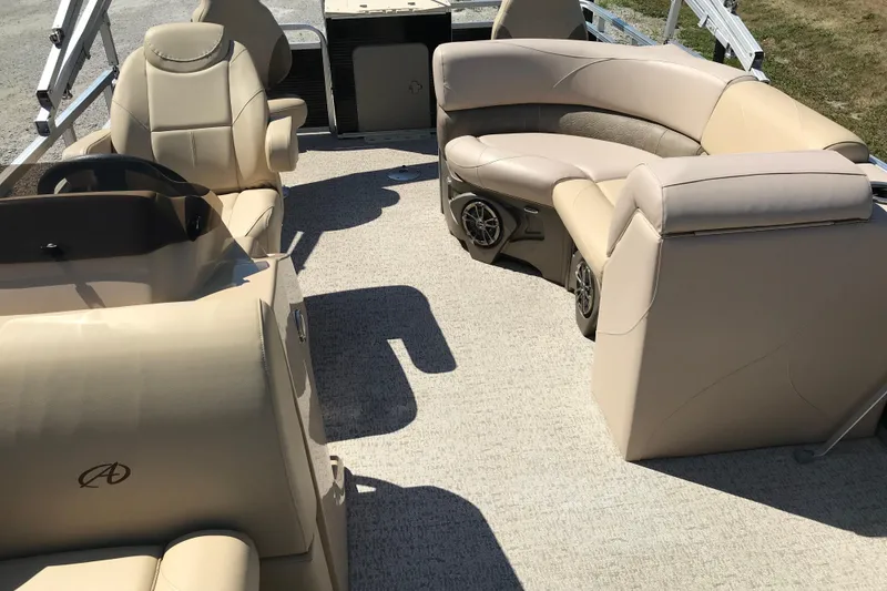 Slide: The Image of 2019 Avalon Venture Fish N Cruise 20' boat interior with beige seating and steering console. - 18
