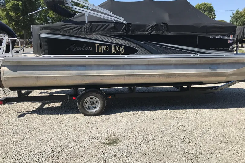 Slide: The Image of 2019 Avalon Venture Fish N Cruise pontoon boat on trailer, covered and parked on gravel. - 21