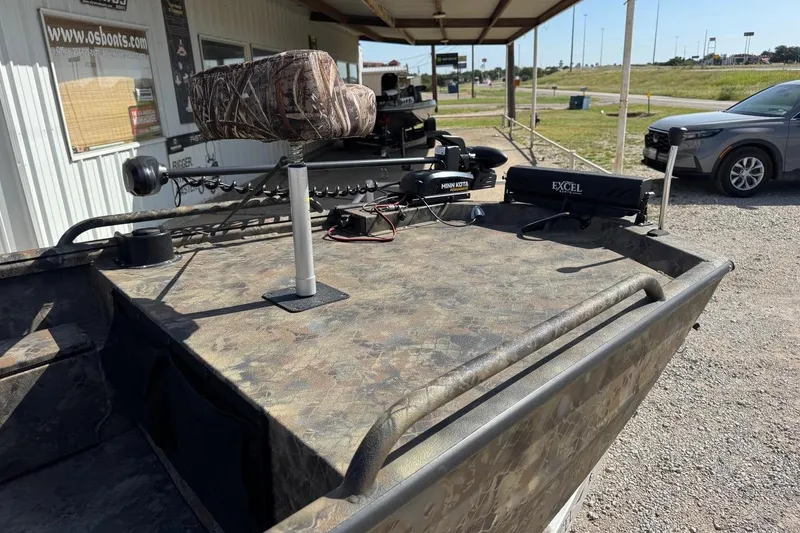 Slide: The Image of 2023 Excel 1751V4M boat with camo design, featuring Minn Kota trolling motor, parked outdoors. - 8