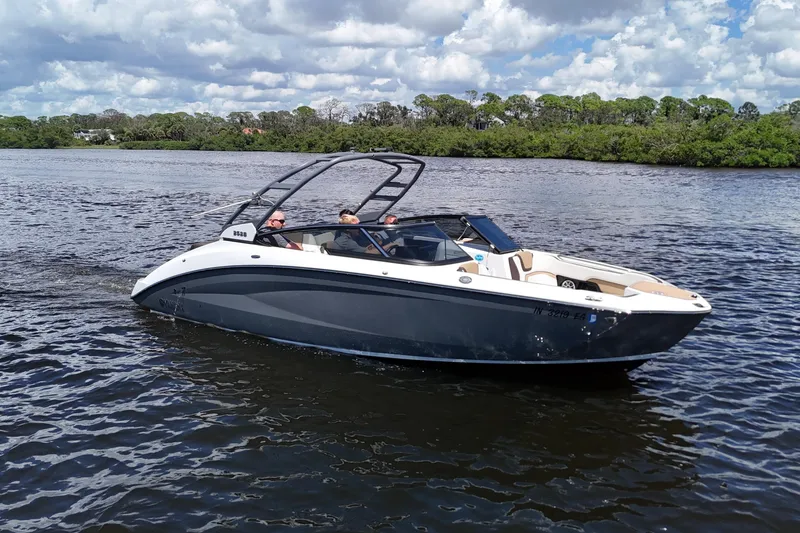 The Image of 2021 Yamaha Boats 252S cruising on a scenic river under a partly cloudy sky. - 0