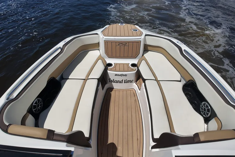 Slide: The Image of 2021 Yamaha Boats 252S interior with cushioned seating and teak flooring on water. - 12