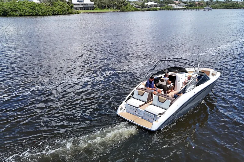 Slide: The Image of 2021 Yamaha Boats 252S cruising on a serene lake with passengers onboard. - 21