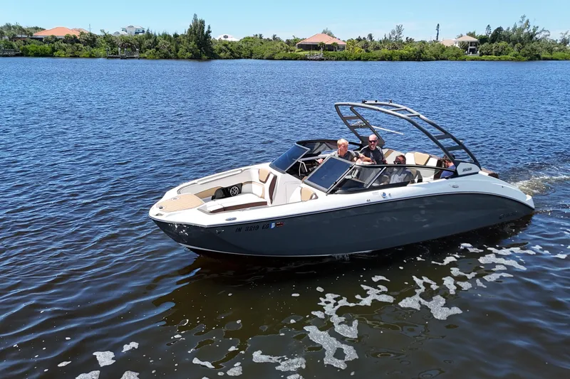 Slide: The Image of 2021 Yamaha Boats 252S cruising on a serene lake with passengers onboard. - 23
