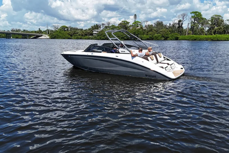 Slide: The Image of 2021 Yamaha Boats 252S cruising on a scenic river under a partly cloudy sky. - 5
