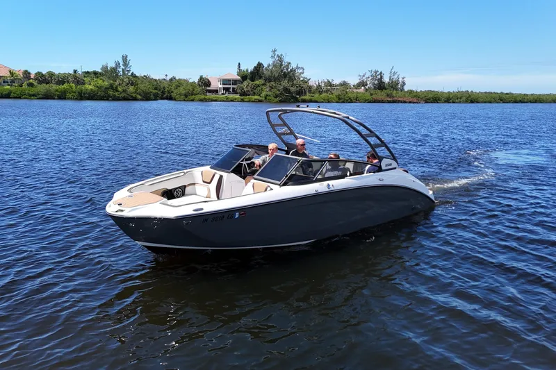 Slide: The Image of 2021 Yamaha Boats 252S cruising on a serene lake under a clear blue sky. - 7