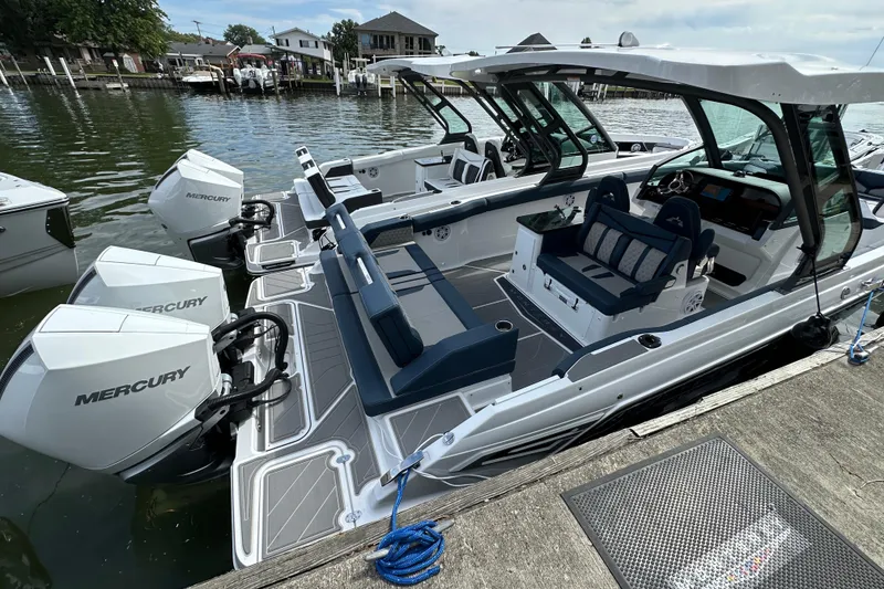 Slide: The Image of 2026 Monterey Elite 30 OB boat with Mercury engines docked at a marina. - 4