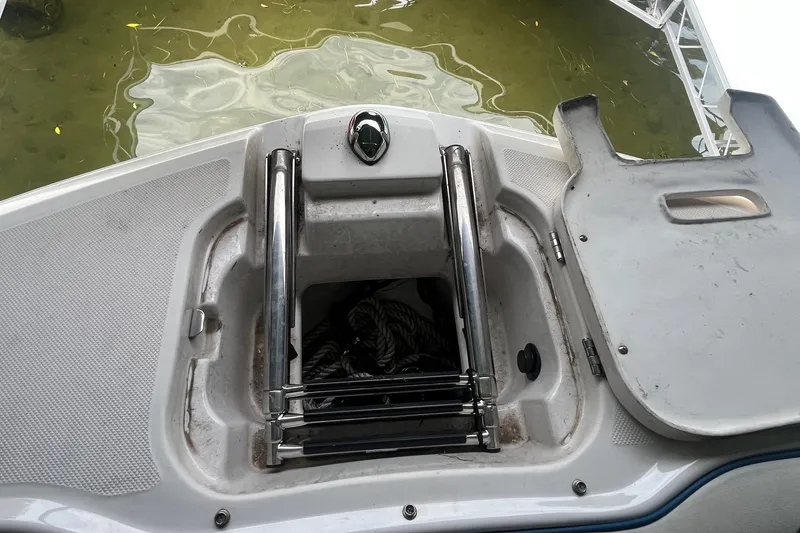 Slide: The Image of 2016 Regal 22 FasDeck ESX boat ladder and storage compartment by water. - 24