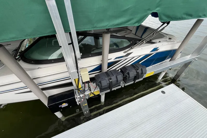 Slide: The Image of 2016 Regal 22 FasDeck ESX boat on lift, covered, dockside view. - 3