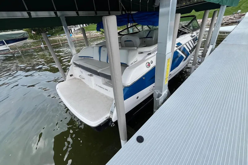 Slide: The Image of 2016 Regal 22 FasDeck ESX boat docked in a covered slip on a lake. - 6