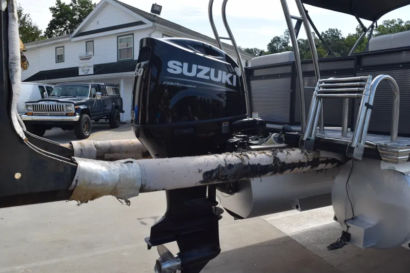 Slide: The Image of 2023 Qwest E Class-820 RLS-Lt boat with Suzuki outboard motor in a parking lot. - 4