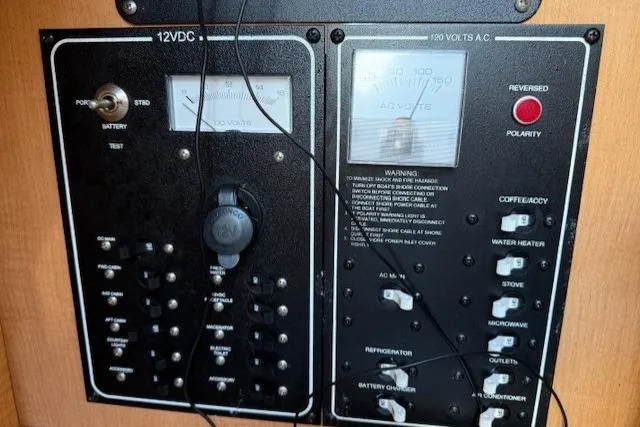 Slide: The Image of Electrical control panel on a 2013 Glastron GS 289 boat, featuring 12VDC and 120VAC systems. - 14