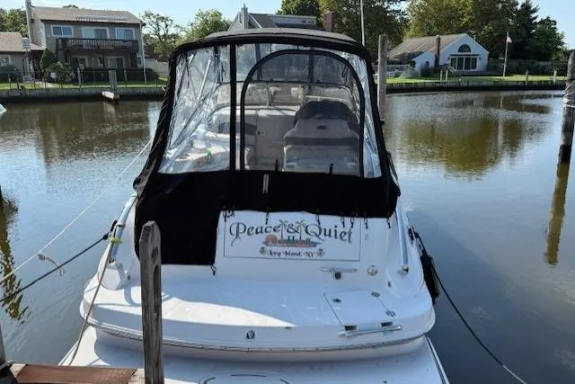 Slide: The Image of 2013 Glastron GS 289 boat docked in a serene residential canal setting. - 2